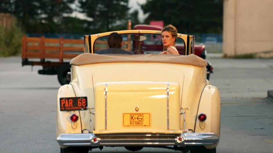 Helen looks backwards while being driven away by Eddie Rothberg.