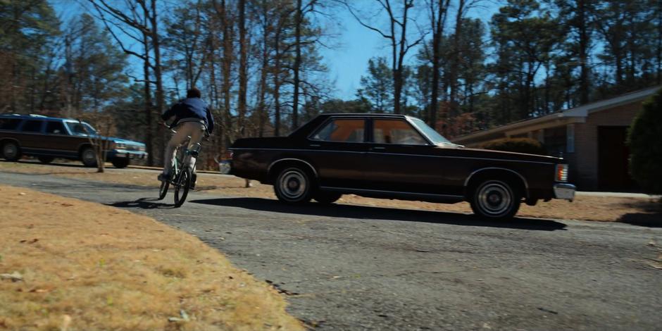 Lucas rides off through his driveway.