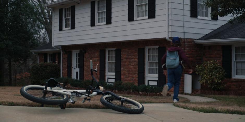 Dustin runs up to the house after dropping his bike in the driveway.