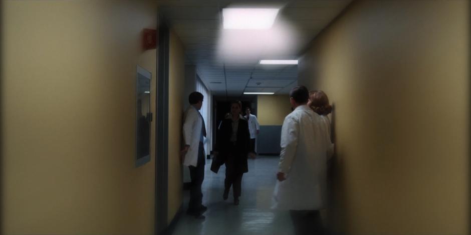 Terry Ives walks down the hallway as scientists cower out of the way.