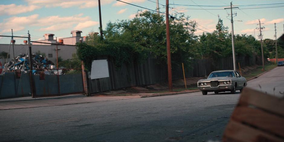 Nancy and Jonathan drive down the street through an industrial area.