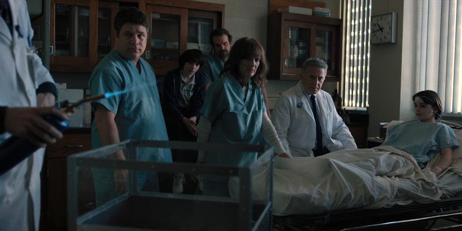 Everyone watches as a lab worker prepares an experiment with one of the vines.