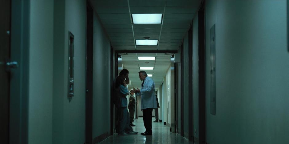 Dr. Owens talks to Joyce and Hopper in the hallway.