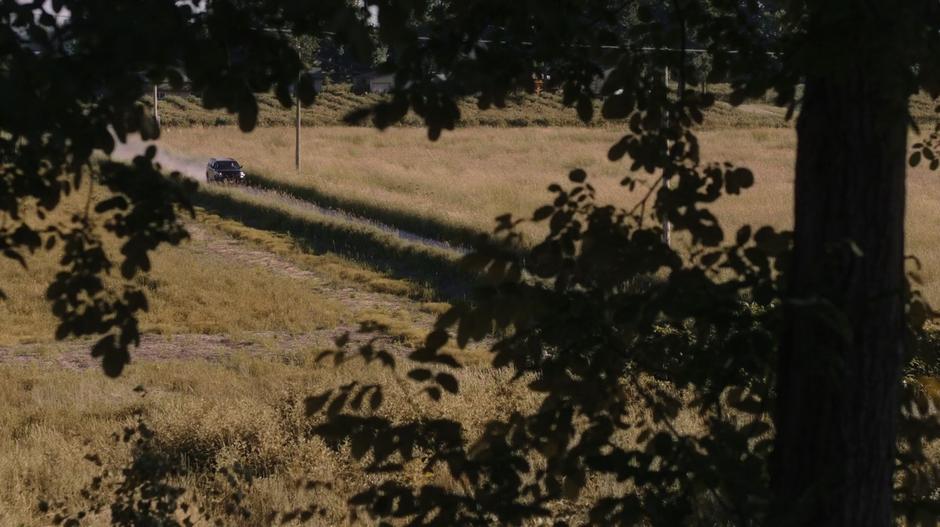 Priest comes down the drive to the house.