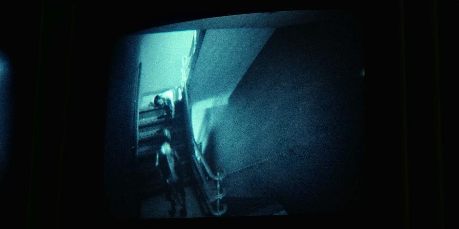 A demodog runs up the stairs on a security camera.