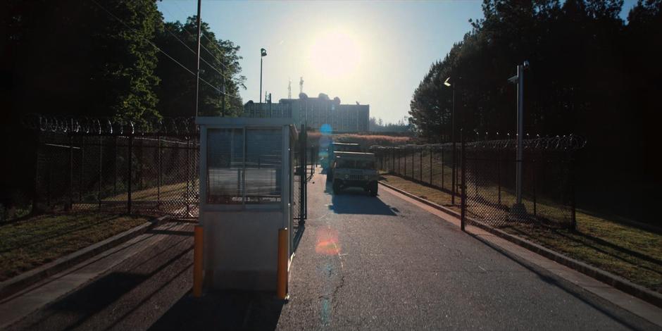 The military convoy drives through the front gates of the facility.