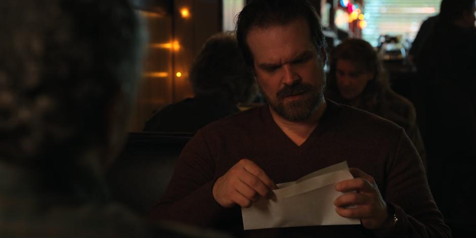 Hopper looks at the new birth certificate that Dr. Owens got him for Eleven.