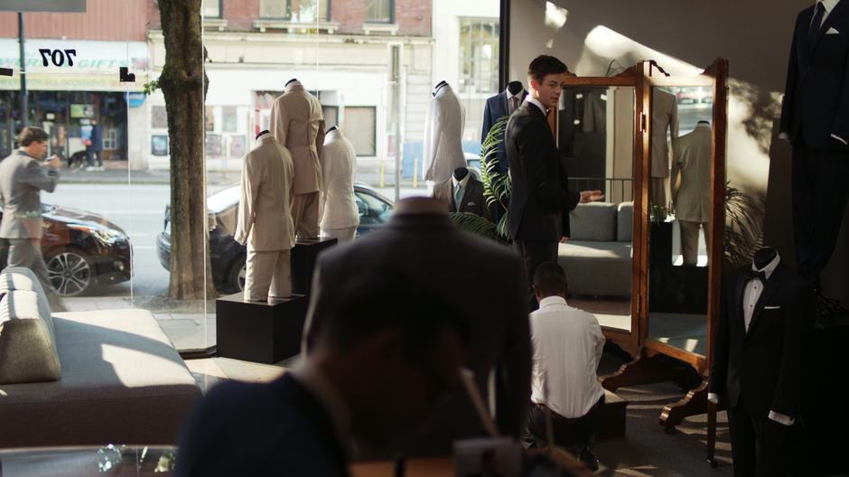 An employee makes the final adjustments to Barry's tux.