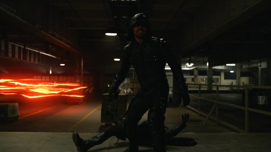 Oliver knocks out one Earth-X solider while Barry zips around in the background.