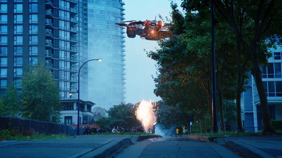 The evil WaveRider flies over a group of fleeing civilians firing down on them.