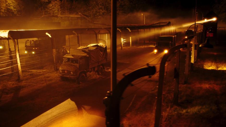 A truck drives into the camp between the fences.