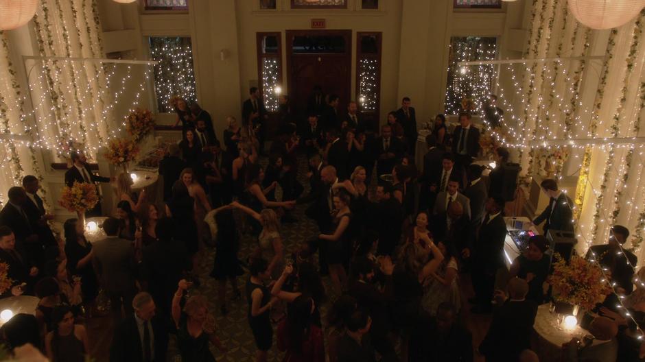 All of Oliver and Felicity's friends dance on the lower level of the party.