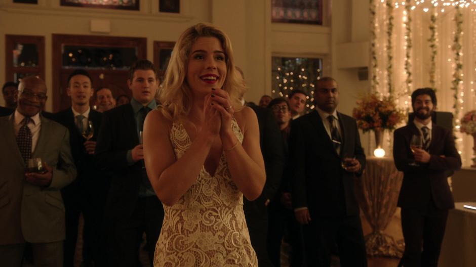 Felicity smiles as Curtis catches the bouquet.