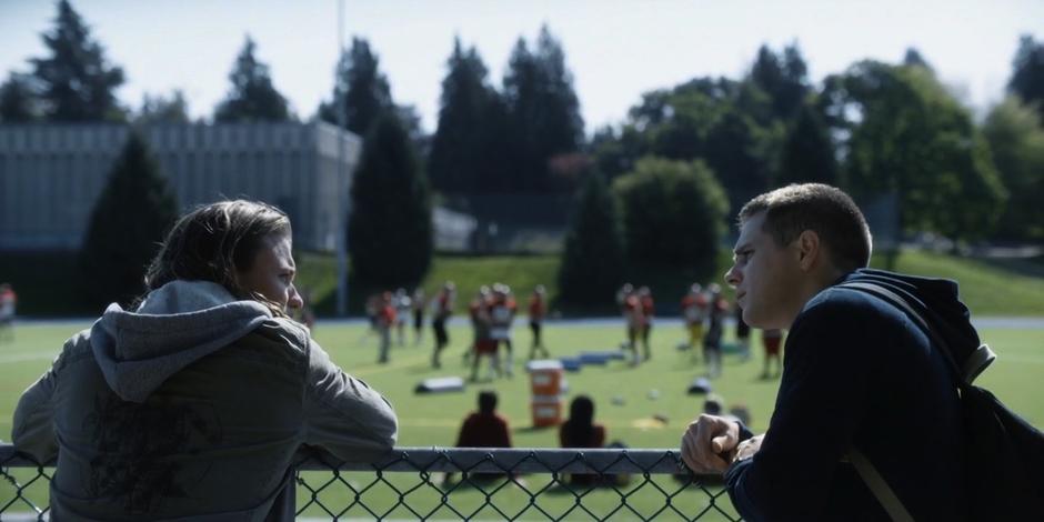 Trevor talks to Kyle on the fence by the sports fields.