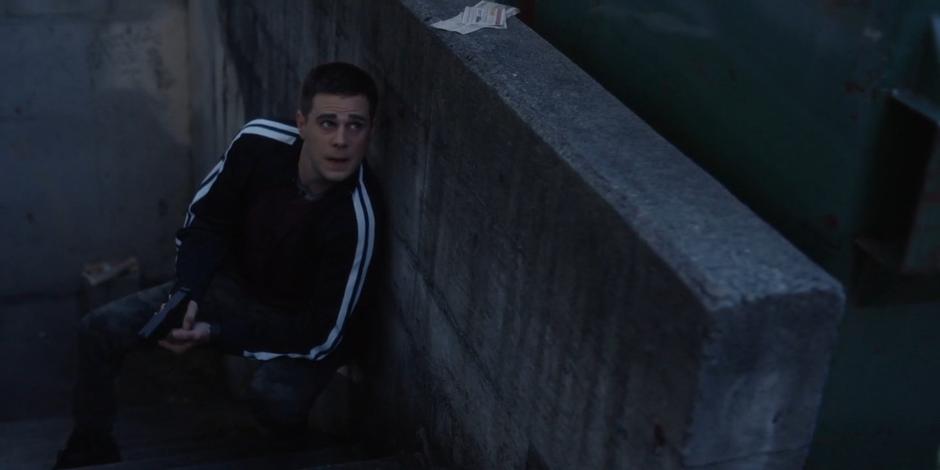 Trevor takes shelter behind a concrete wall near the parking lot.