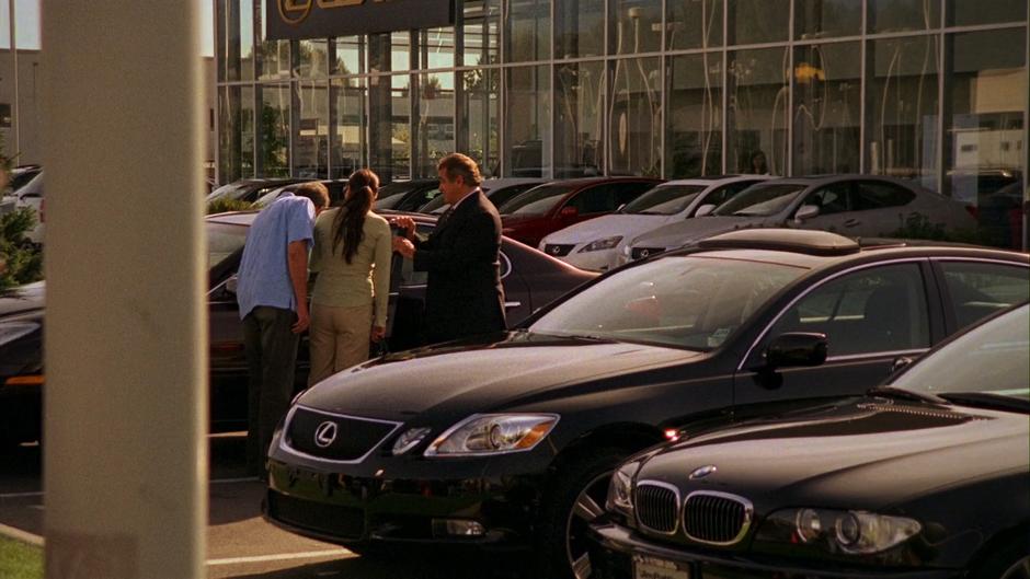 Bill Peterson sells a car to a couple on the car lot.