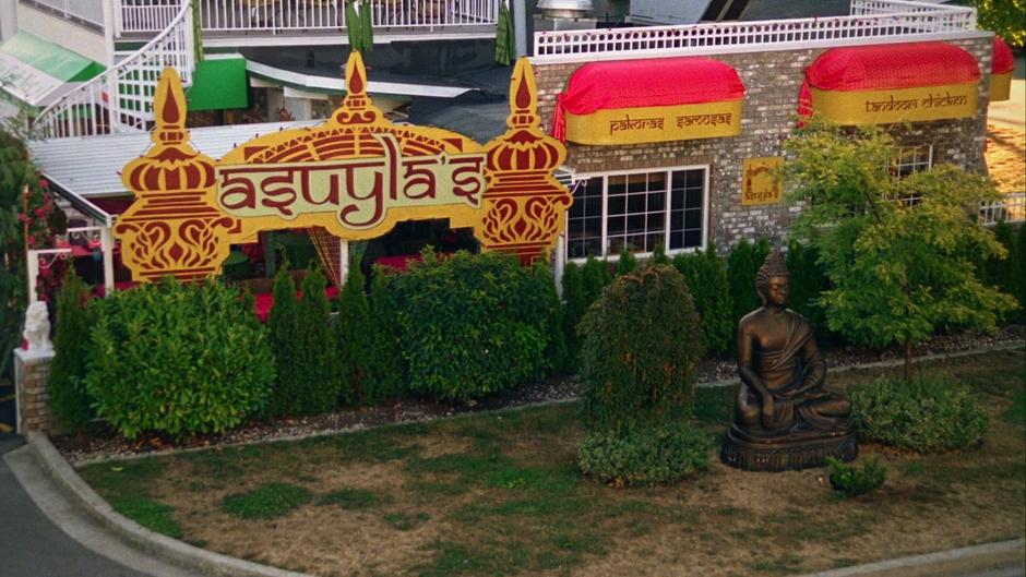 The Indian restaurant is visible across the street from the apartment through the window.