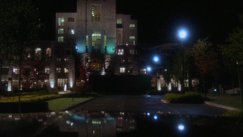 The mental institution is visible through the front window of the car.