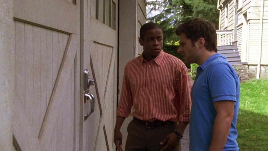 Gus looks at Shawn as he examines the lock on the shed.