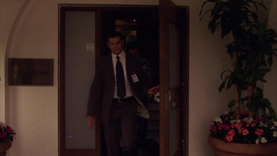 Lassiter walks out through the front door of the station.