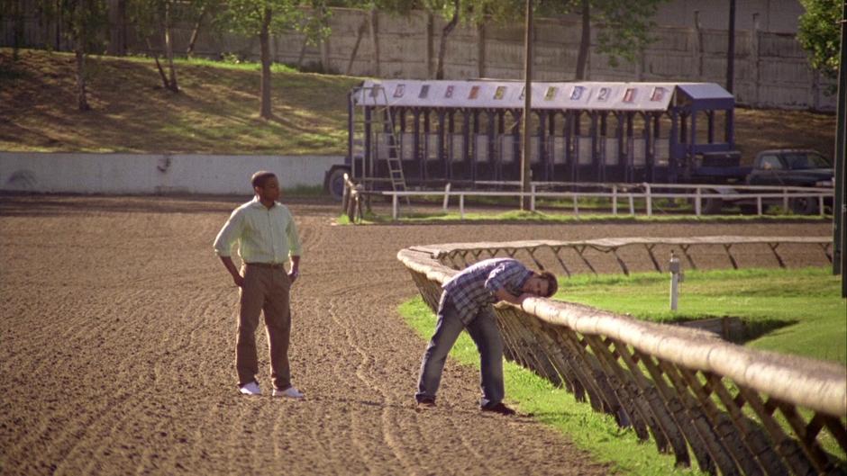 Gus watches Shawn as he examines the rail on the track.