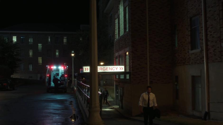 Mulder walks out into the parking lot behind the hospital.