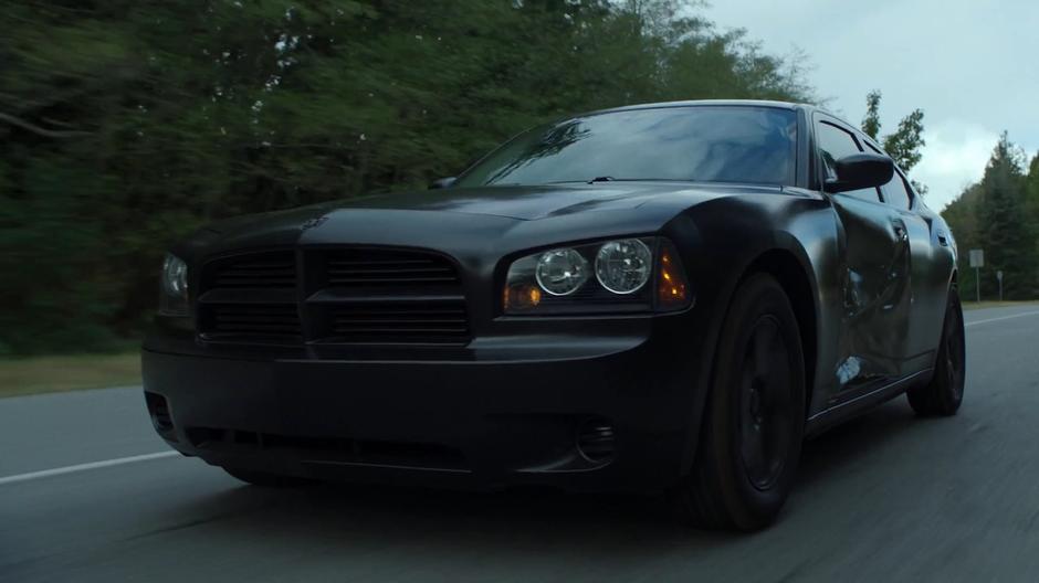 The driver's damaged car drives down the highway.