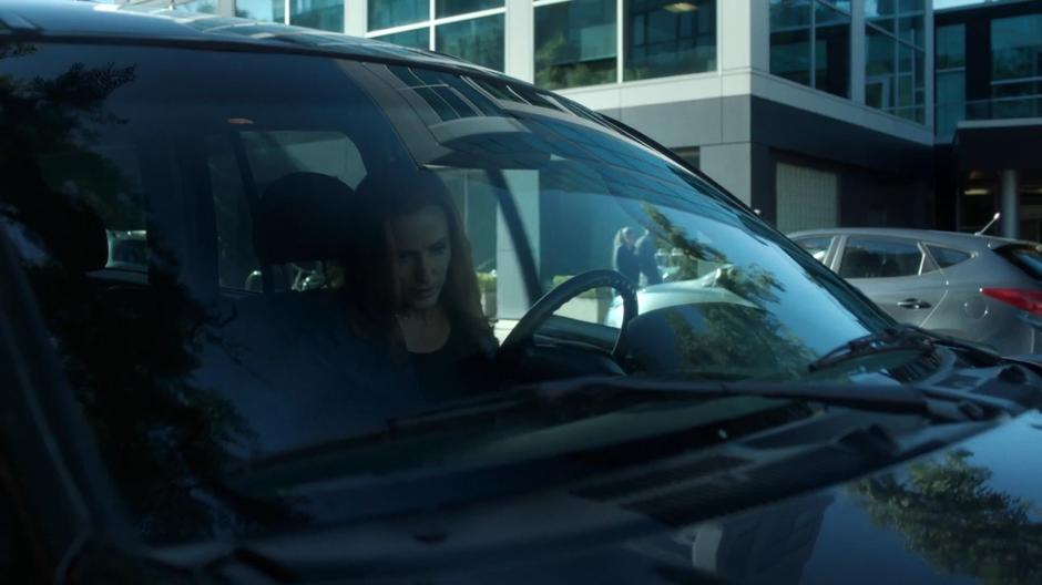 Scully gets into her car where it is parked on the side of the road.