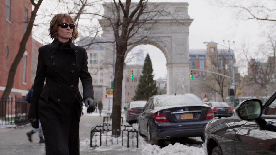 Lenny Cohen walks back to her car with the prominent arch in the background.