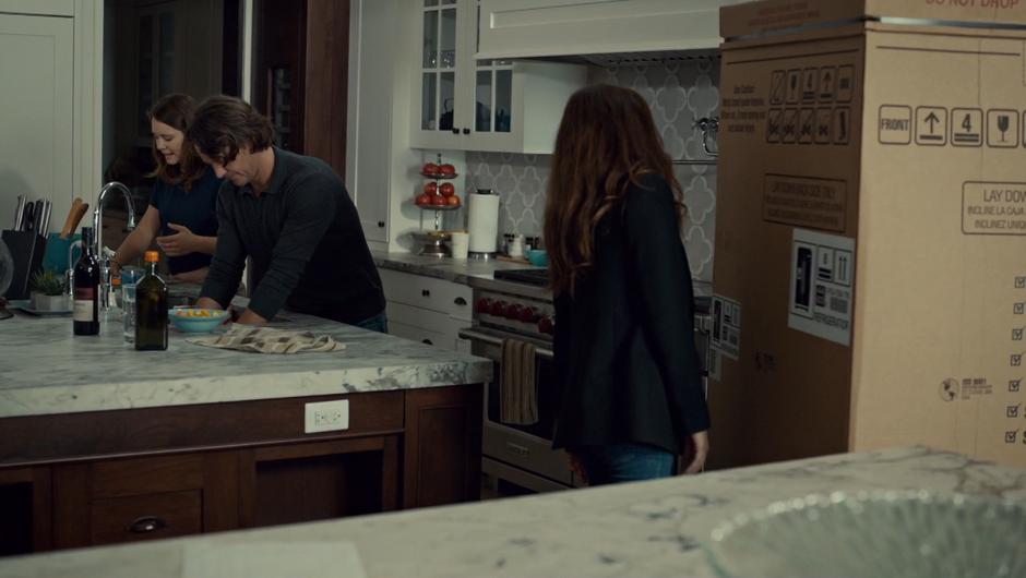 Jess chats with her father while Mary examines the refrigerator box.