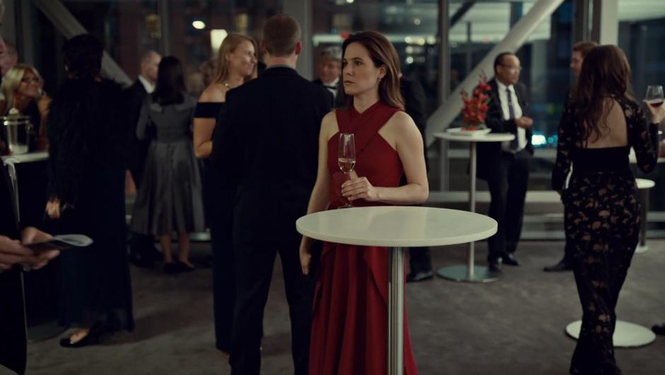 Mary stands at a table in the lobby during intermission waiting for her client.