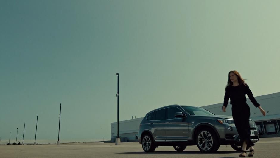 Mary walks from her car towards the entrance.