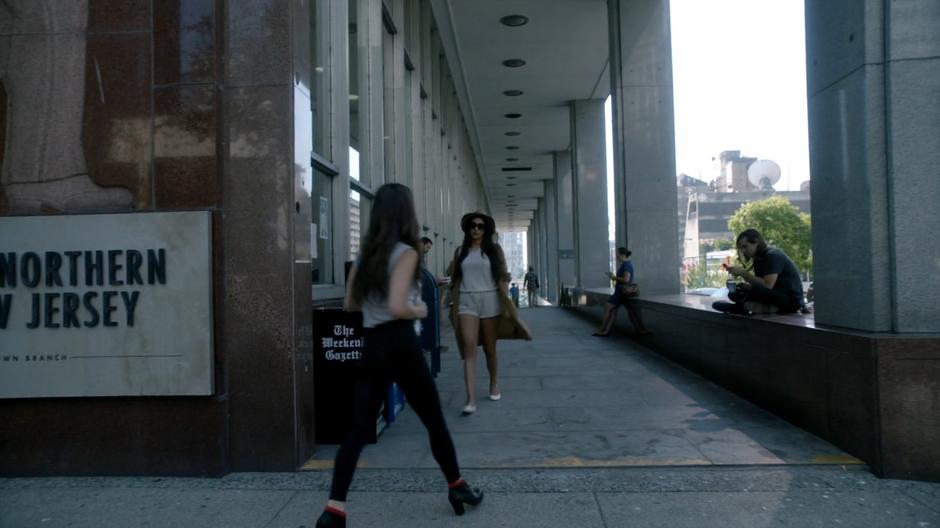 Julia walks around the corner to where Quentin is waiting outside.