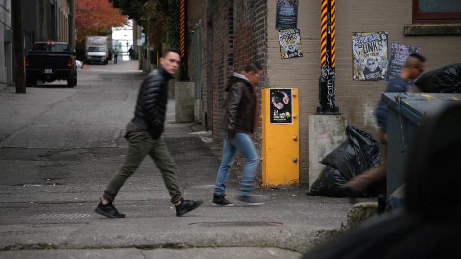 Three bystanders turn away and continue walking.