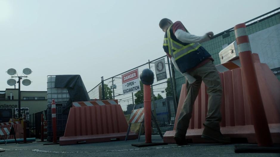 The remaining construction worker grips his leg as the creature climbs up.