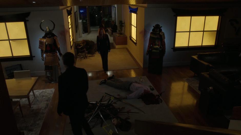 Mulder and Scully examine the decapitated body of Dean Cavalier in the middle of the floor.