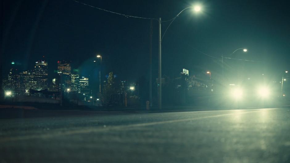 Mary drives down the street with the skyline in the background.