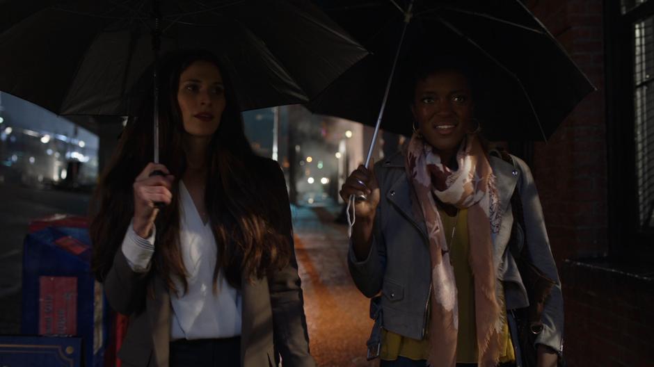 Vanita and Julia Freeman walk down the street in the rain.