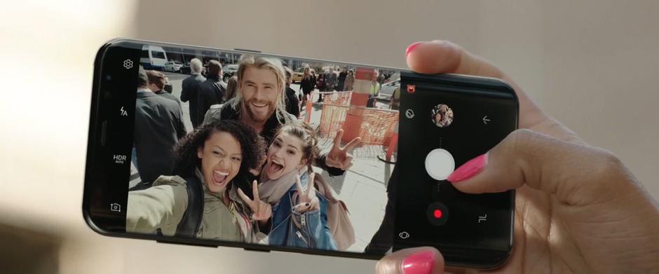 Two young women take a selfie with Thor.