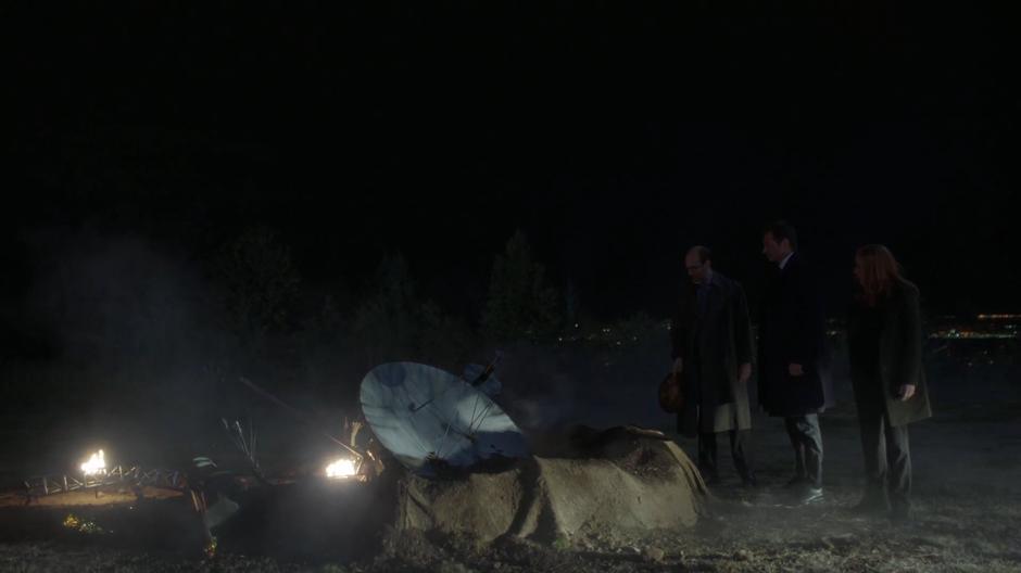 Reggie, Mulder, and Scully examine the remains of the Voyager spacecraft.