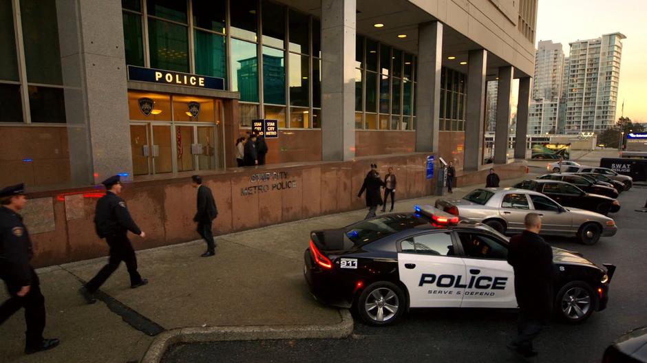 Establishing shot of the outside of the new station with a number of police cars parked out front.