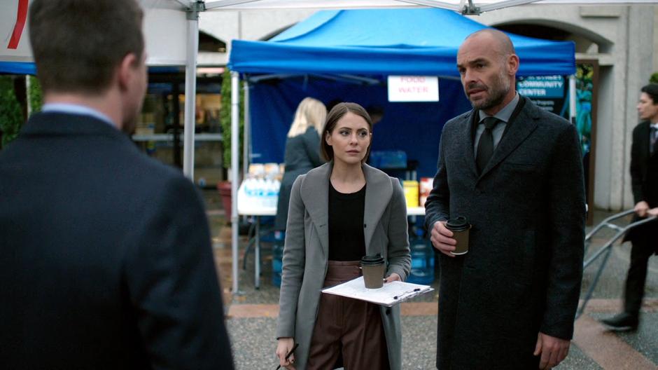 Thea and Lance stand in the middle of the empty safe area talking to Oliver.