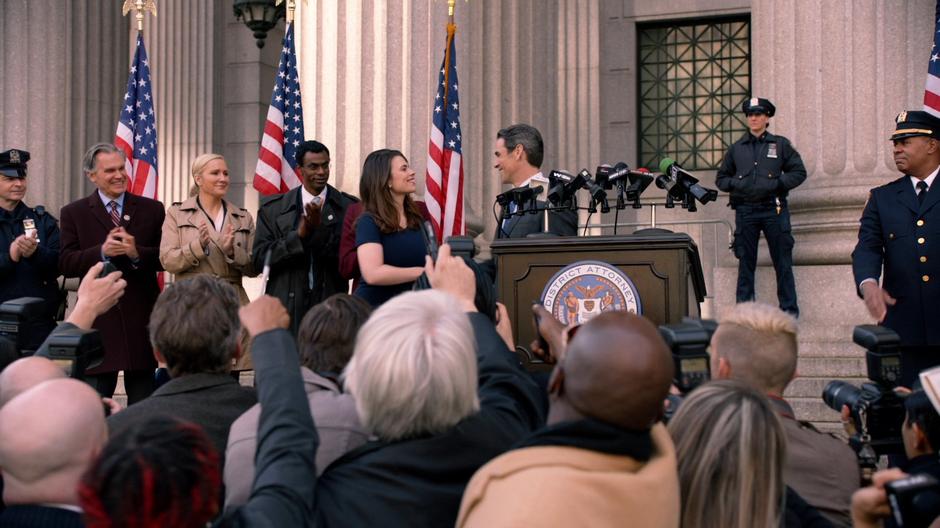 Hayes shakes Wallace's hand after he announces her role in the Conviction Integrity Unit.