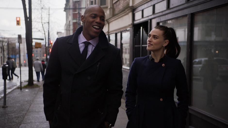 James and Lena chat while walking down the street.