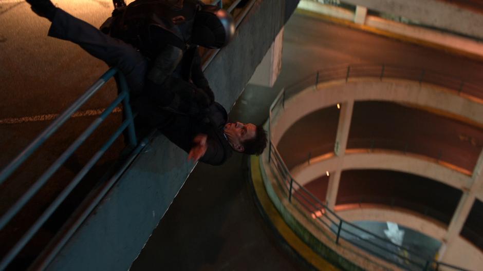 James in the Guardian suit holds Edge over the railing.