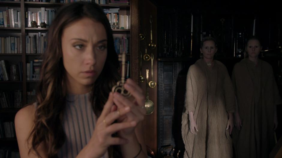 Two strange individuals appear behind Julia as she holds the Truth Key.