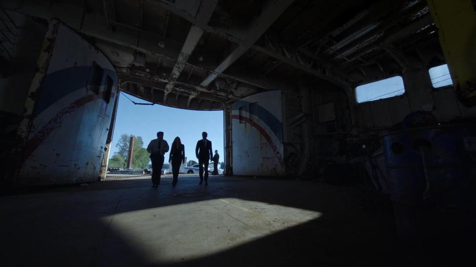 Detective Costa escorts Scully and Mulder into the bowels of the ship.