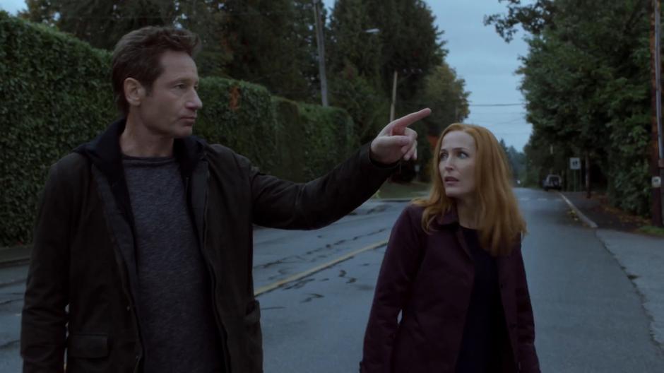 Mulder points out the security camera to Scully.