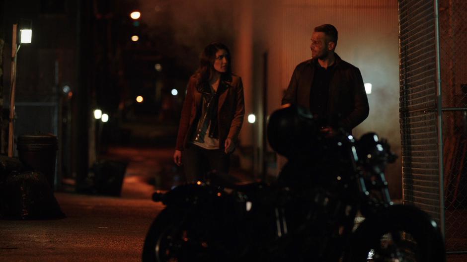 Dinah walks Vincent over to his motorcycle in the alley.