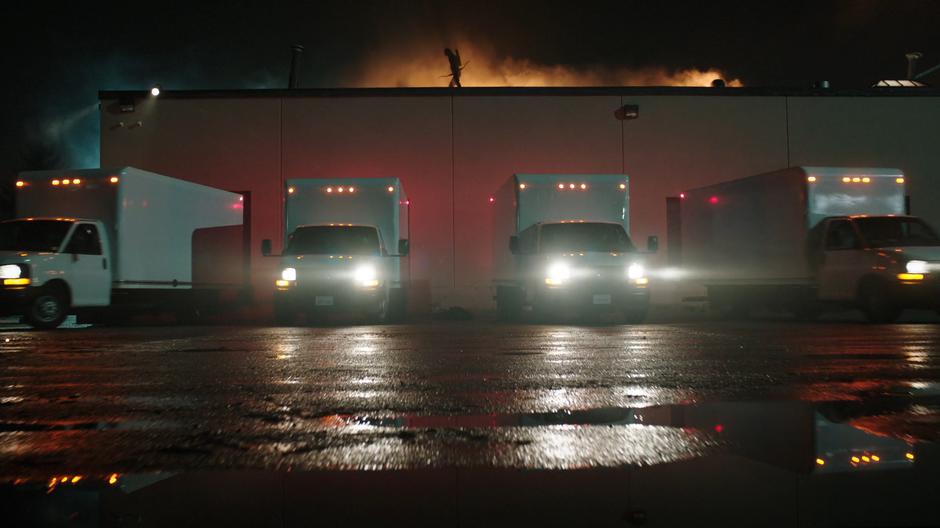 Oliver watches from the roof as four identical trucks drive away.